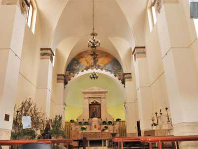 Varchiamo l'entrata, ritrovandoci in un ambiente a navata unica. Il bianco delle pareti e delle volte fa risaltare i lampadari di ottone...